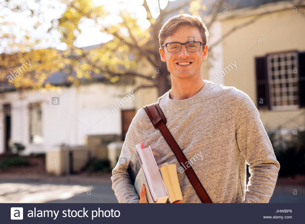 glucklich-mannliche-college-student-im-freien-mit-buchern-junger-student-mit-buchern-auf-dem-campus-jhwbp8.jpg